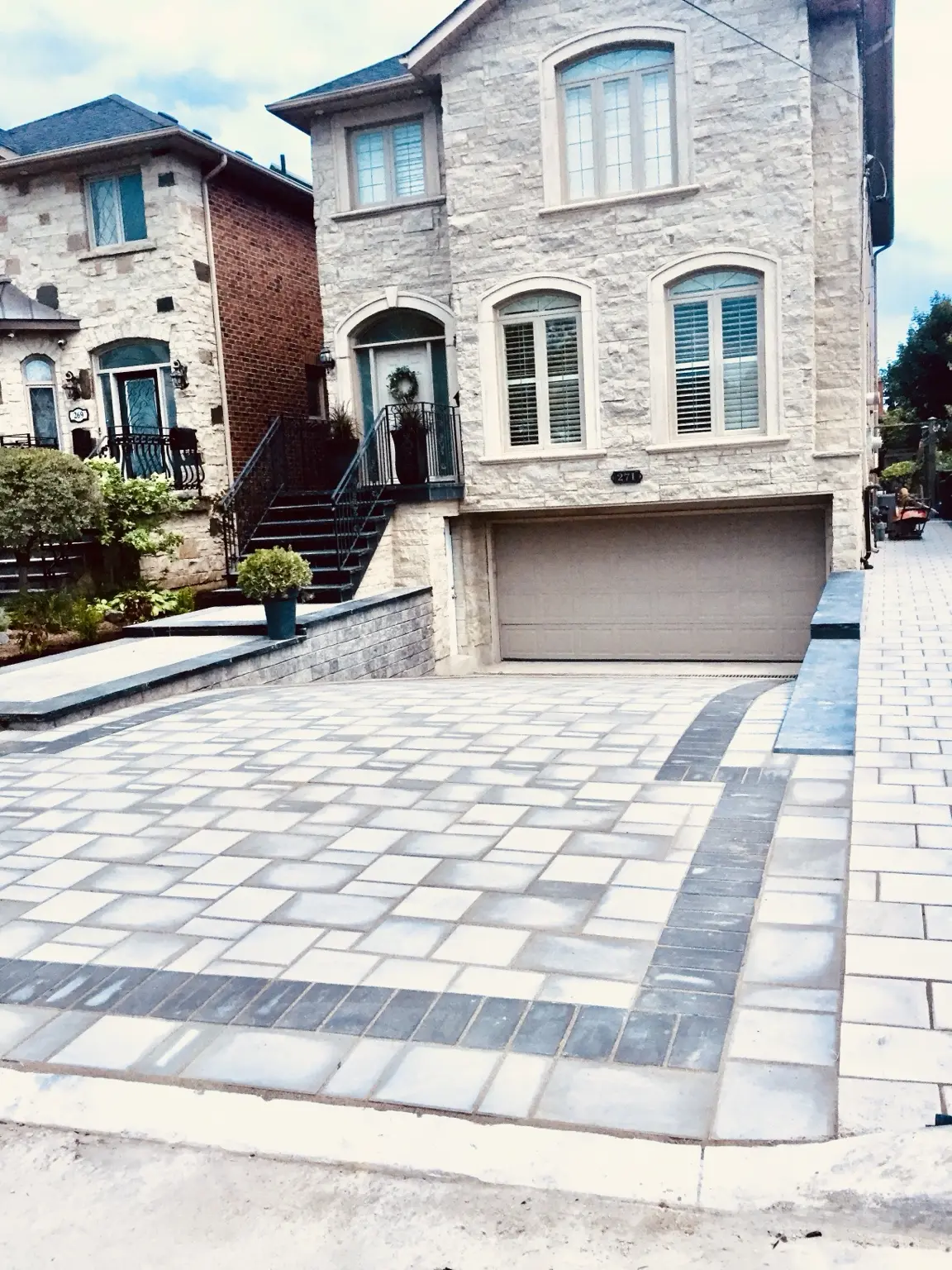 Coordinated interlock driveway, stone retaining walls and renovated home entrance