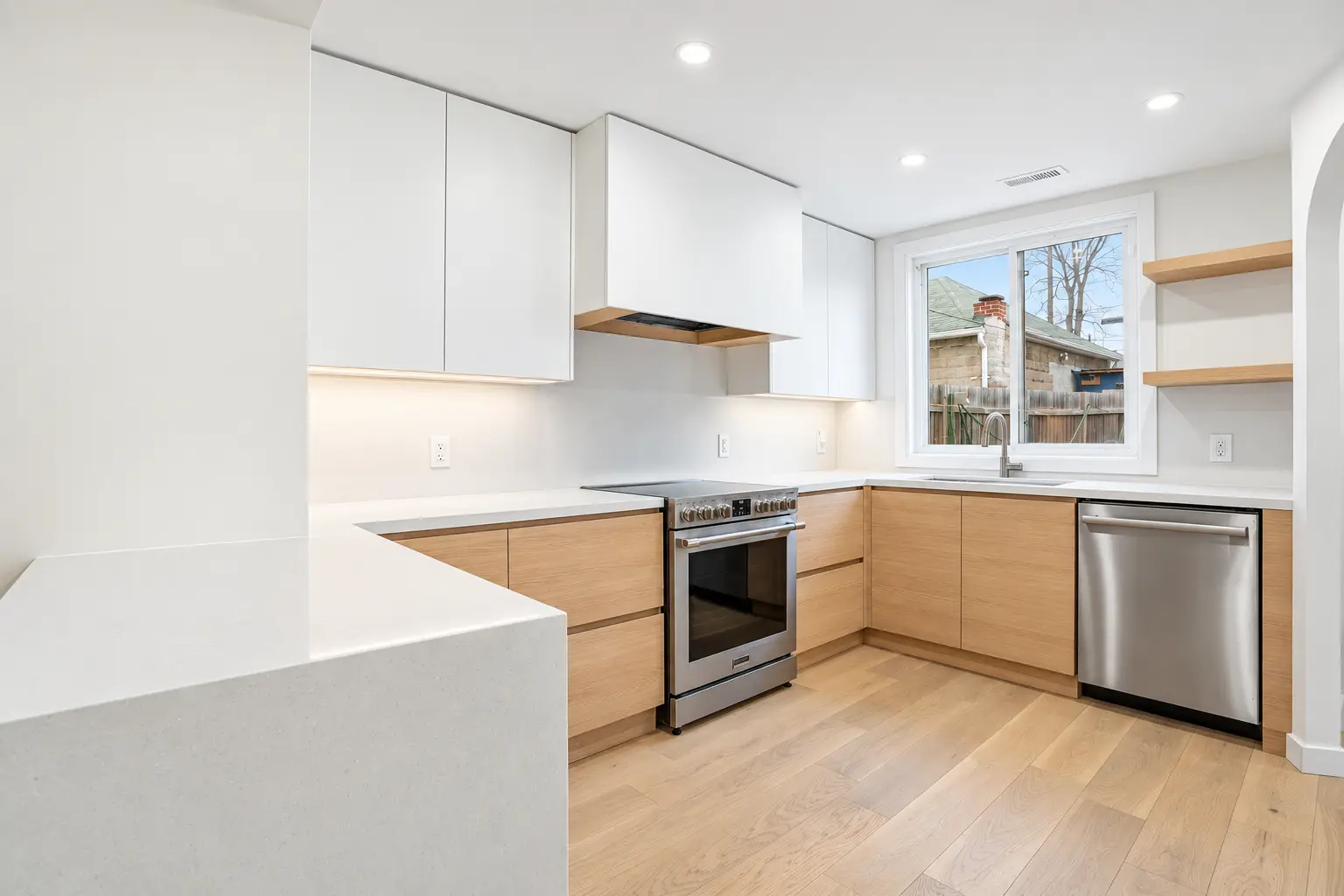 Custom modern kitchen with white upper cabinets, oak lower cabinets and quartz counters