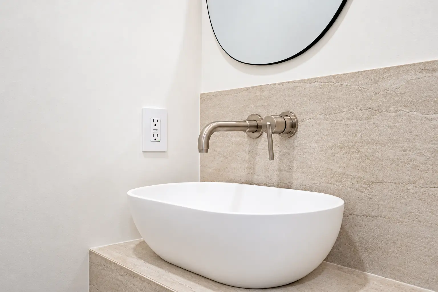 Powder-room vessel sink with wall-mounted brushed metal faucet and stone backsplash