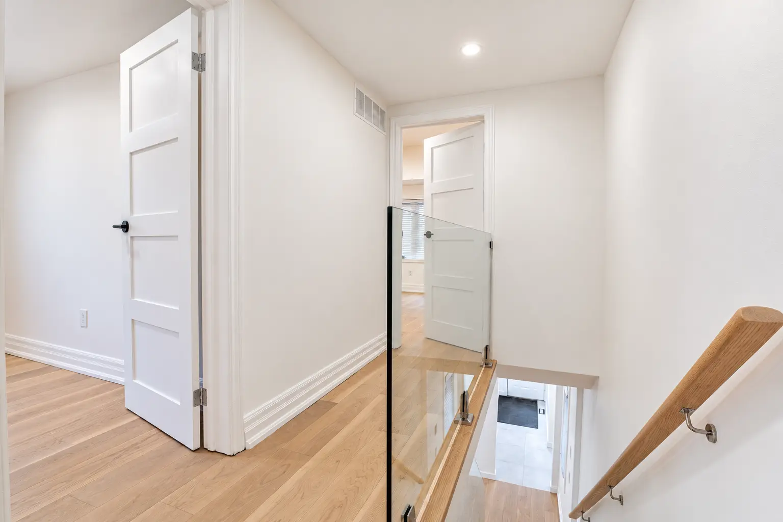 Second-floor hallway with new oak flooring and glass stair guard