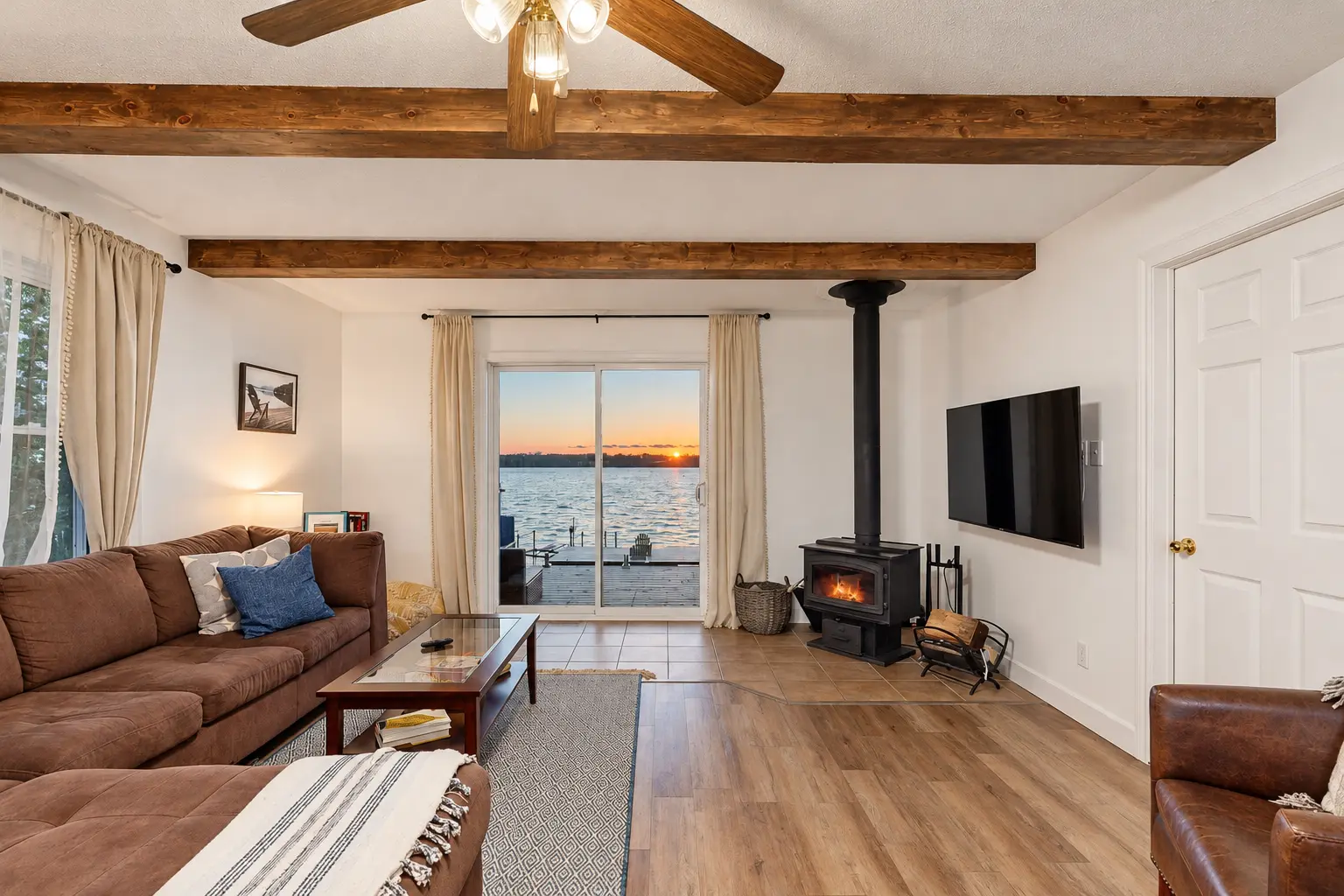 Painted cottage living room with decorative wood ceiling beams and lake view