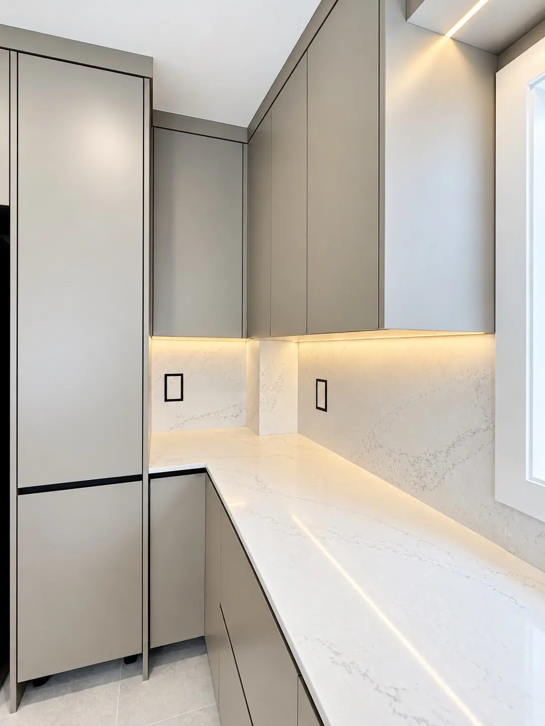 Floor-to-ceiling flat-panel kitchen cabinetry with quartz counters and black detailing
