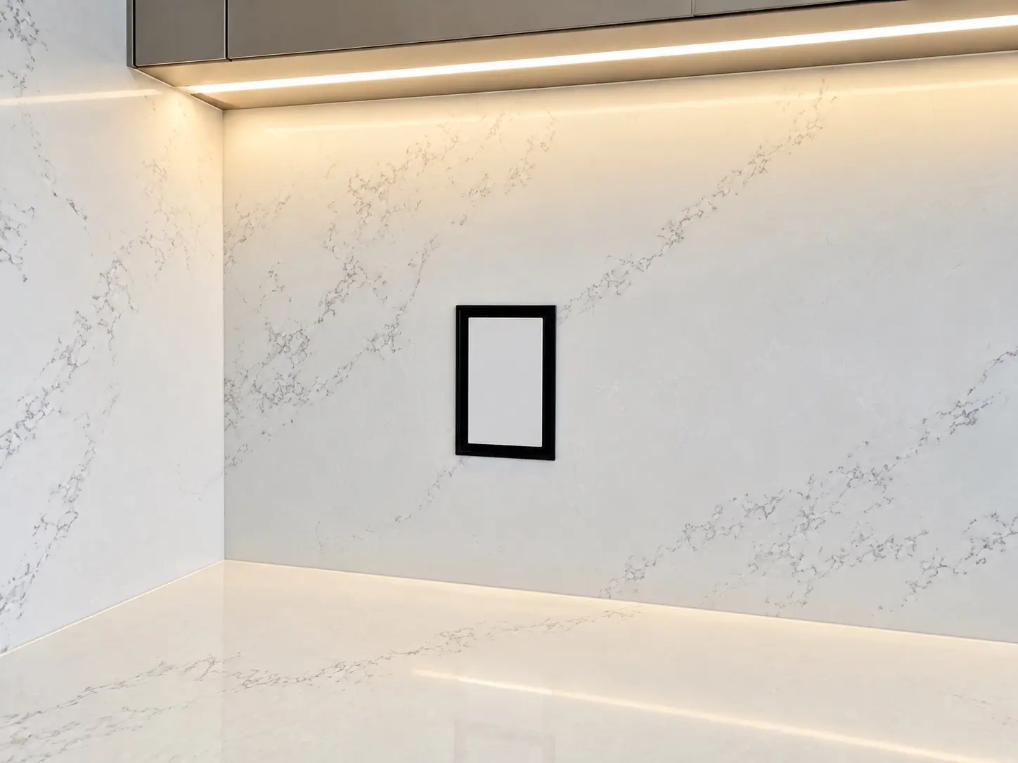 Full-height quartz backsplash and counter illuminated by integrated under-cabinet lighting