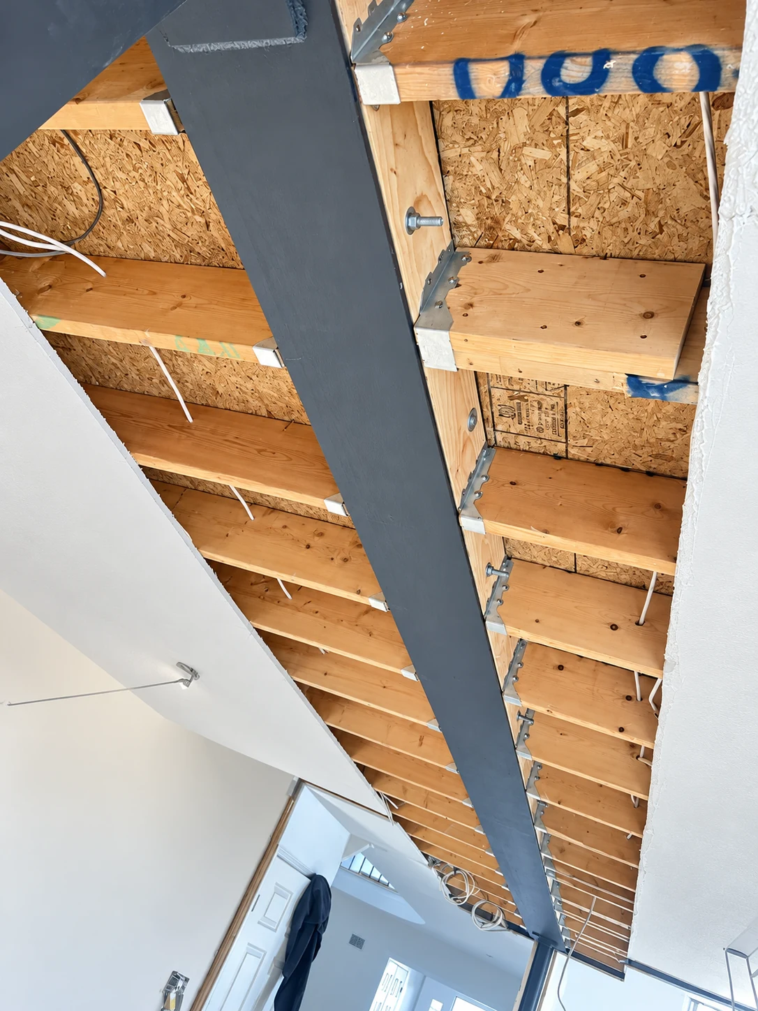 Steel beam integrated with joists and framing during the open-concept renovation