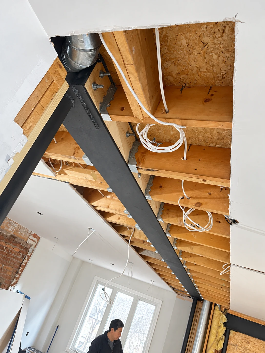 Structural steel beam installed beneath the exposed floor framing